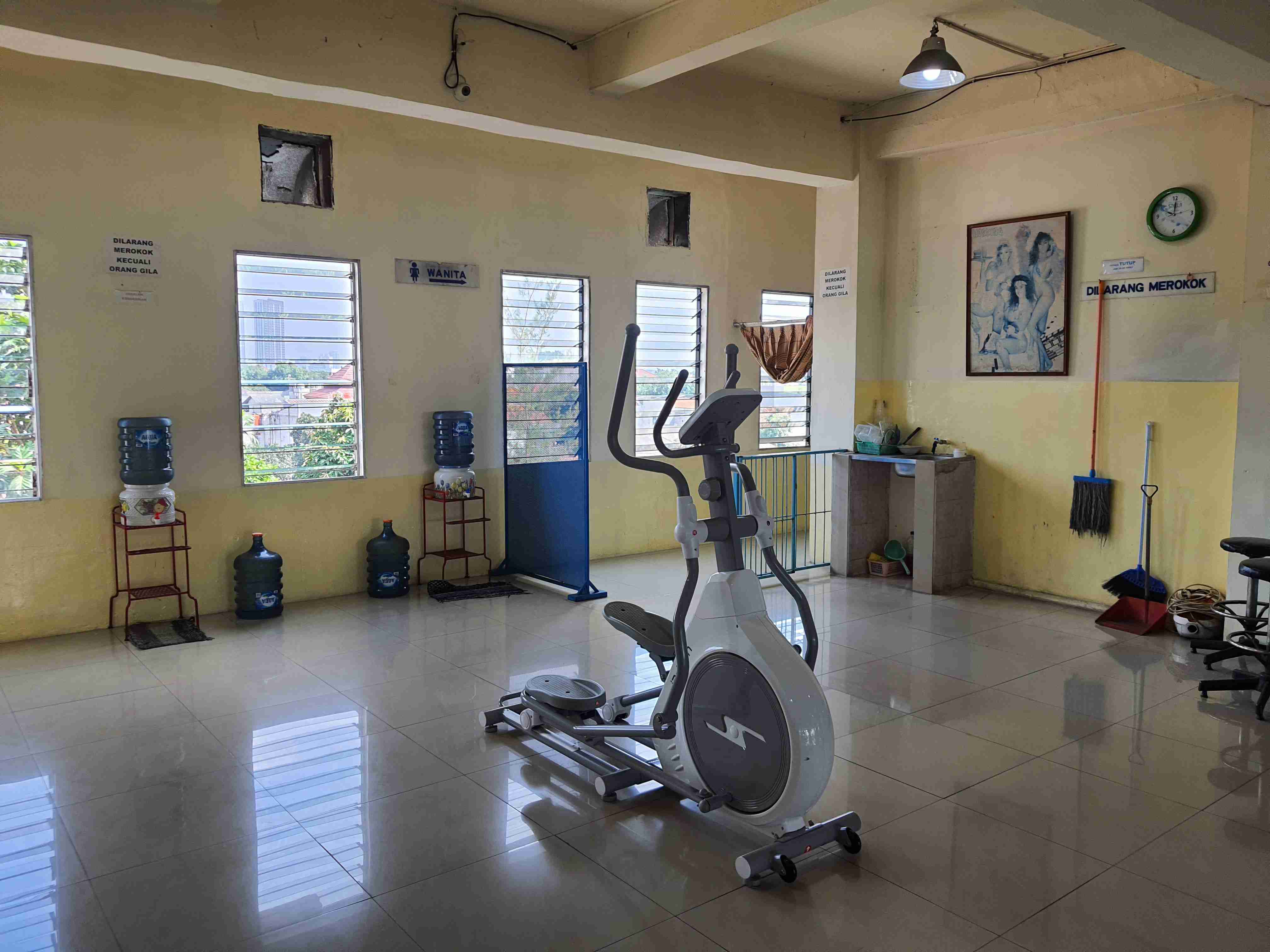 Foto mesin elliptical berada di tengah ruangan gym.